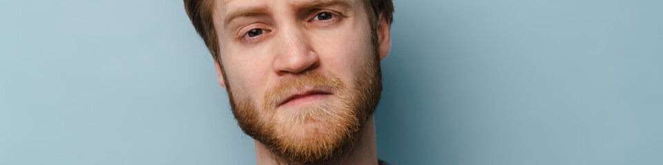 Obraz premium White ginger man with beard frowning and looking at camera