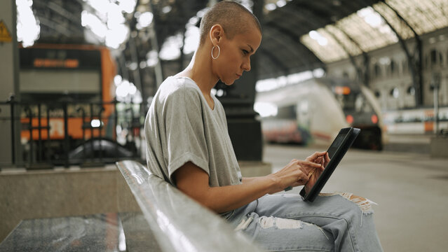 Adult woman with short hairstyle using tablet computer at station