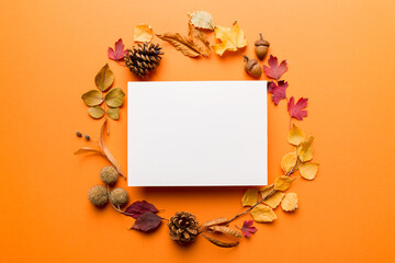 Autumn composition with paper blank and dried leaves on table. Flat lay, top view, copy space