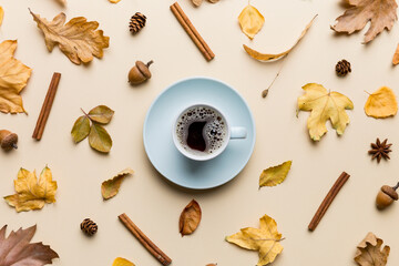 Flat lay composition with colorful Autumn cup of coffee and leaves on a color background. top view