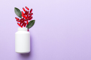different drugs and health supplement pills poured from a medicine bottle health care and medical top view on colored background