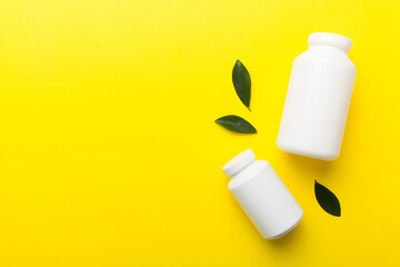 supplement pills with medicine bottle health care and medical top view. Vitamin tablets. Top view mockup bottle for pills and vitamins with green leaves, natural organic bio supplement, copy space