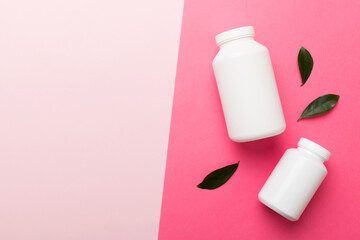 supplement pills with medicine bottle health care and medical top view. Vitamin tablets. Top view mockup bottle for pills and vitamins with green leaves, natural organic bio supplement, copy space