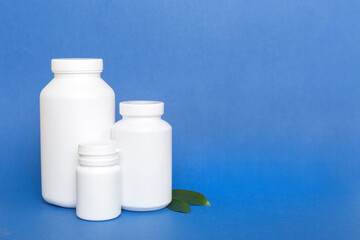 supplement pills with medicine bottle health care and medical top view. Vitamin tablets. Top view mockup bottle for pills and vitamins with green leaves, natural organic bio supplement, copy space