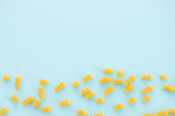 uncooked italian spiral pasta on blue background.