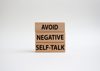 Avoid negative self-talk symbol. Concept words Avoid negative self-talk on wooden blocks. Beautiful white background. Business and Avoid negative self-talk concept. Copy space.