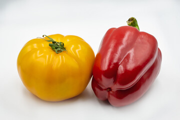 Whole yellow tomato and red bell pepper closeup