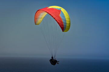 2022-06-26 A INDIVIDUAL PARA SAILING WITH A MULTI COLORED SAIL AND A CLEAR BLUE SKY NEAR LA JOLLA CALIFORNIA