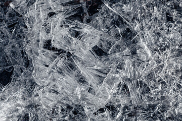 Natural background of ice crystals randomly covering a dark surface