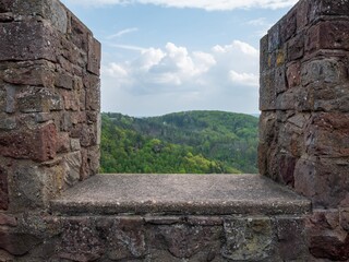 blick durch eine Burgmauer auf die Eifel.
