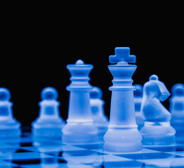 Glass chess on chess board. Photographed up close with the black background.