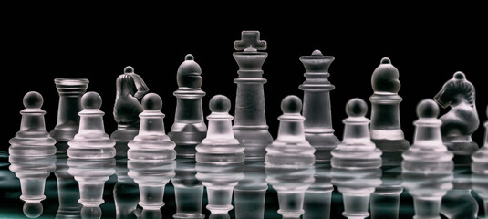 Glass chess on chess board. Photographed up close with the black background.