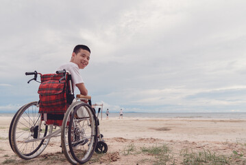 Young man with disability happy face, smiling on the beach,Outdoor vacation in summer,People leisure travel, mental health concept,Positive of lifestyle,International Day of Persons with Disabilities.