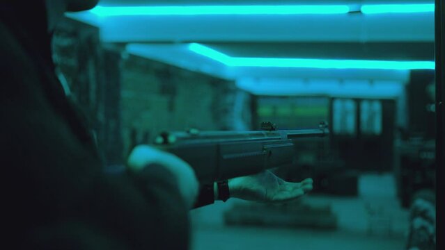 Player or shooter loading bullet and shooting to targets inside shooting range . Training practice or competition which requires great aiming accuracy and precision . Shot on ARRI Cinematic camera