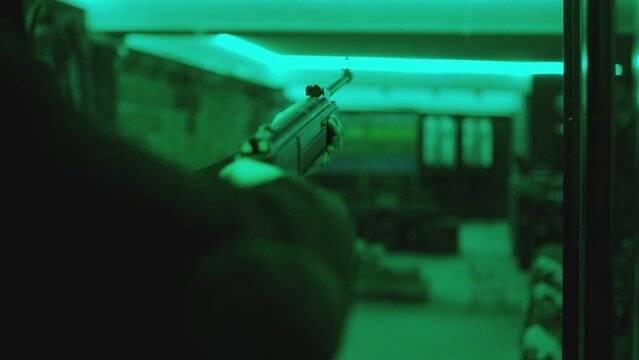 Player or shooter loading bullet and shooting to targets inside shooting range . Training practice or competition which requires great aiming accuracy and precision . Shot on ARRI Cinematic camera
