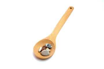 Wooden spoon with sea pebbles on an isolated white background.