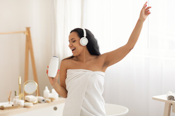 Obraz na płótnie Canvas Happy Black Female Singing Holding Shampoo Bottle Standing In Bathroom