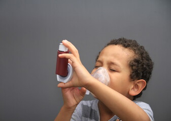 boy with hay fever inhaler on grey background stock photo