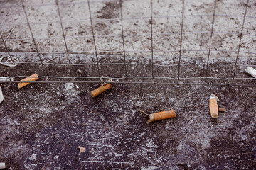 old cigarettes stubs on a floor