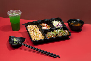TOFU STEAK PREMIUM BENTO with mint margarita, sauce and chopsticks isolated on red background side view of japanese fast food
