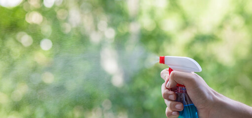 A hand with a spray splashes a cleaner .