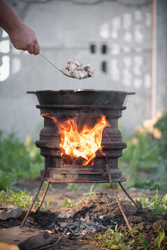 Cooking the meat in the kazan cauldron on the fire close up.