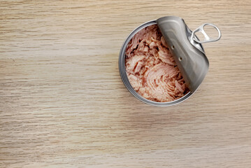 Canned tuna open tin on a wooden background