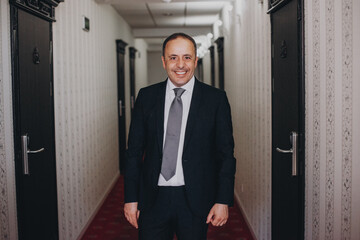 Portrait of a senior groom in suit in the hotel corridor