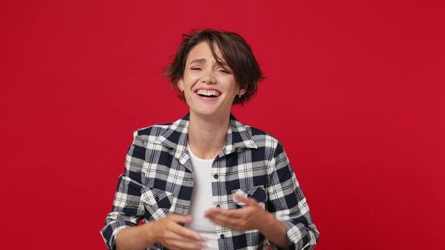 Excited cheerful fun young woman 20s she wears casual clothes look camera laugh smiling watch comedy movie pointing index finger on you isolated against over plain solid dark red color wall background