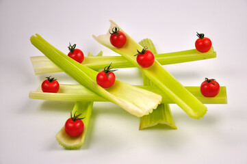 Cherry Tomatoes and Fresh green Celery on white background.