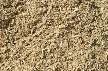 a product of wood processing, in the photo mountains of wood chips and sawdust against a blue sky