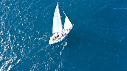 Aerial drone photo of beautiful sail boat anchored in deep blue open ocean sea