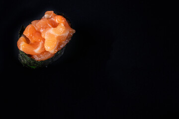 Salmon tartare gunkan maki sushi with fresh raw salmon with copy space on black background