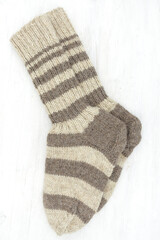 knitted wool winter socks on white wooden background