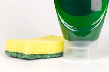 Dishwashing green liquid with a sponge in an upside down bottle front view