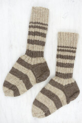 knitted wool winter socks on white wooden background