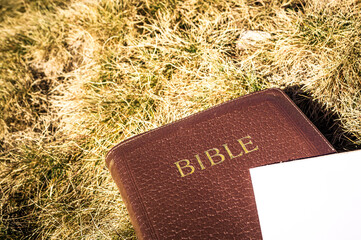 Outdoor Bible study during mountain hike in the fall. Bible, empty notepad and a pencil on a dry...