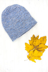 Blue knitted wool winter hat on a white wooden background