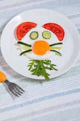 Sunny side egg breakfast, decorated for kids, with animal character. Served with vegetables.