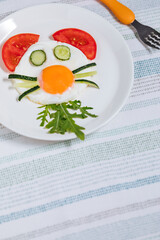Sunny side egg breakfast, decorated for kids, with animal character. Served with vegetables.