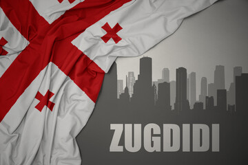 Fototapeta premium abstract silhouette of the city with text Zugdidi near waving national flag of georgia on a gray background.