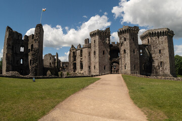 Fototapeta na wymiar The ruins of Raglan castle shot with the footpath leading the focus to the medieval tower itself. The tourist attraction in Monmouthshire South Wales is an impressive relic to see