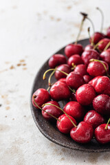 Fresh cherry on ceramic plate with text space. Healthy organic food