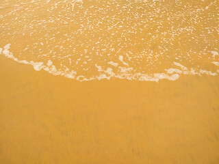 Wave of the sea on the sandy beach background
