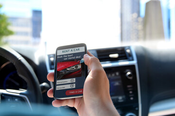 Man is renting a car  with his mobile phone.