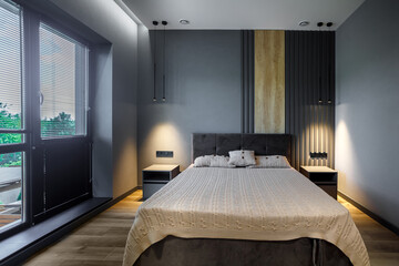 Modern and loft bedroom with dark and grey style. Dark headboard and wooden floor with glass window
