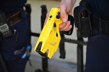 Policjant na służbie z elektrycznym paralizatorem. Tazer. Taser