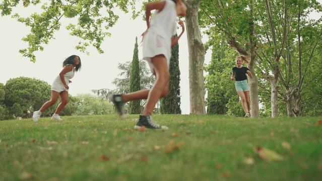 Three girls friends pre-teenage walk in the park playing tag . Three girls friends teenage play got you last game