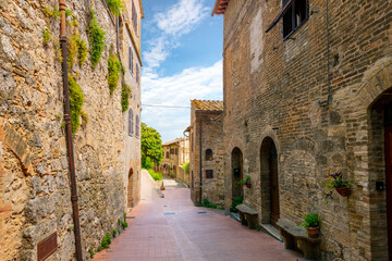 Narrow streets and alleys inside the walls of the medieval hill town of San Gimignano, Italy, in the Tuscany region. - obrazy, fototapety, plakaty