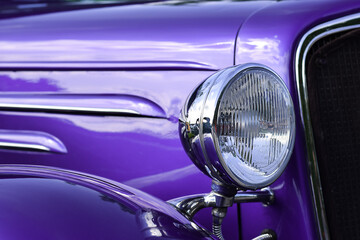 Closeup of headlight of purple retro vintage car